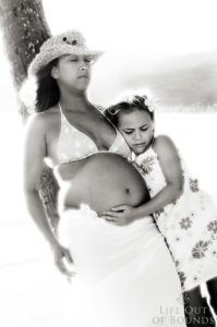Expectant-mother-to-be-hugging-young-daughter-Honolulu-Hawaii
