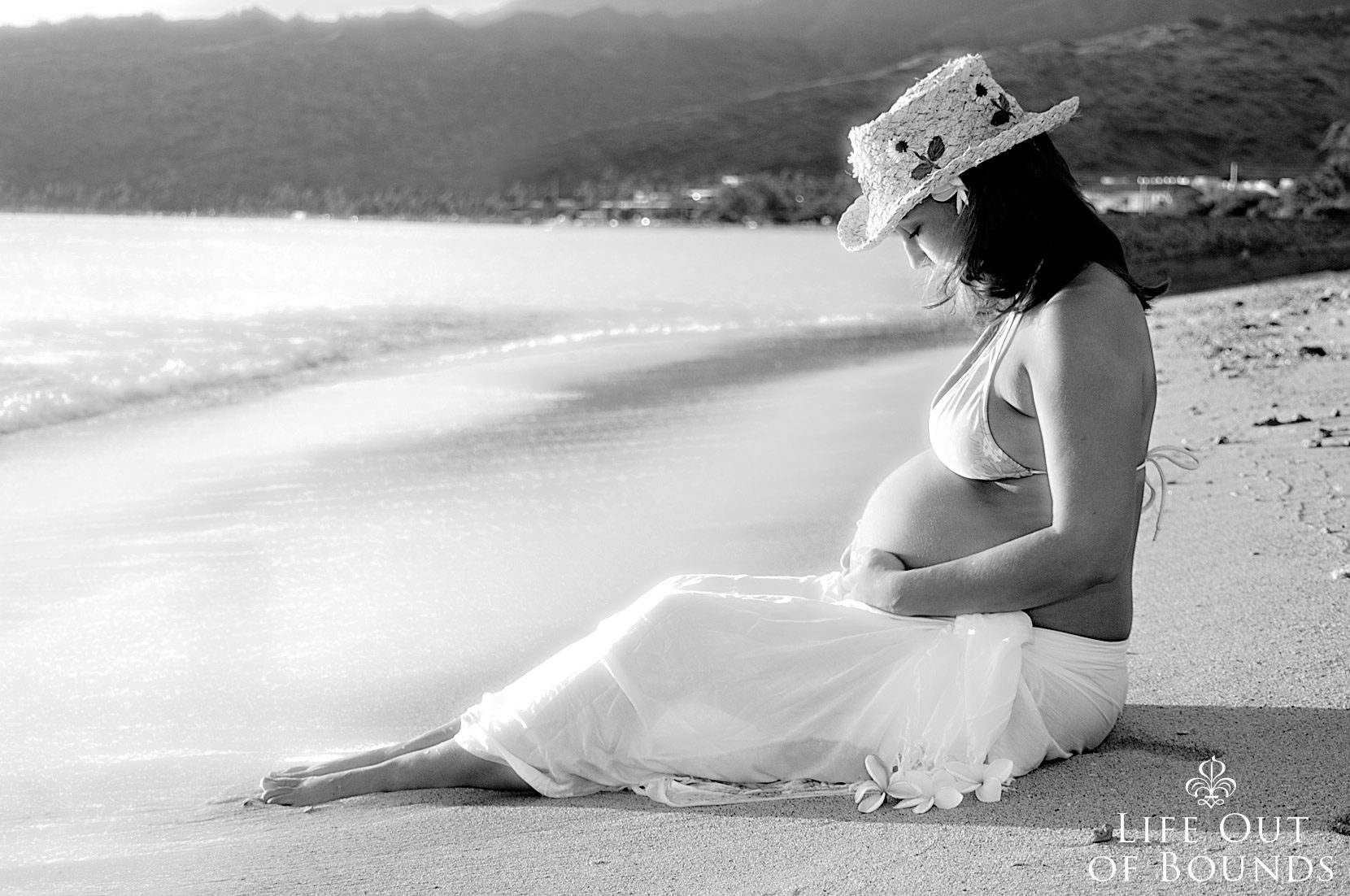 Young-mother-to-be-sitting-on-the-beach-at-sunset-Honolulu-Hawaii
