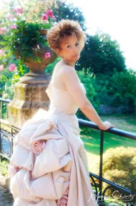 Portrait-of-an-Italian-woman-wearing-a-rose-ball-gown-in-a-garden-setting