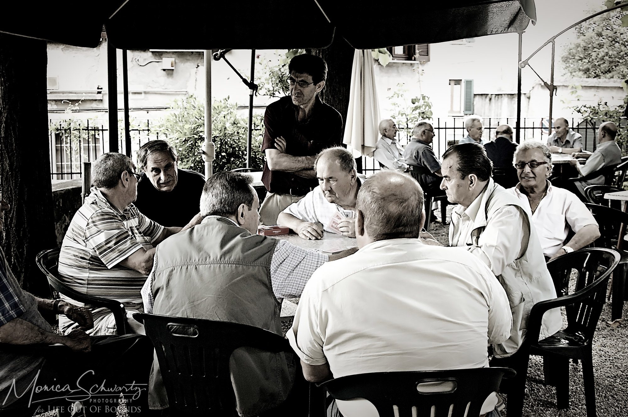 Old-Italian-men-hanging-out-at-the-circolino-on-a-summer-afternoon-in-SantAmbrogio-Varese-Italy