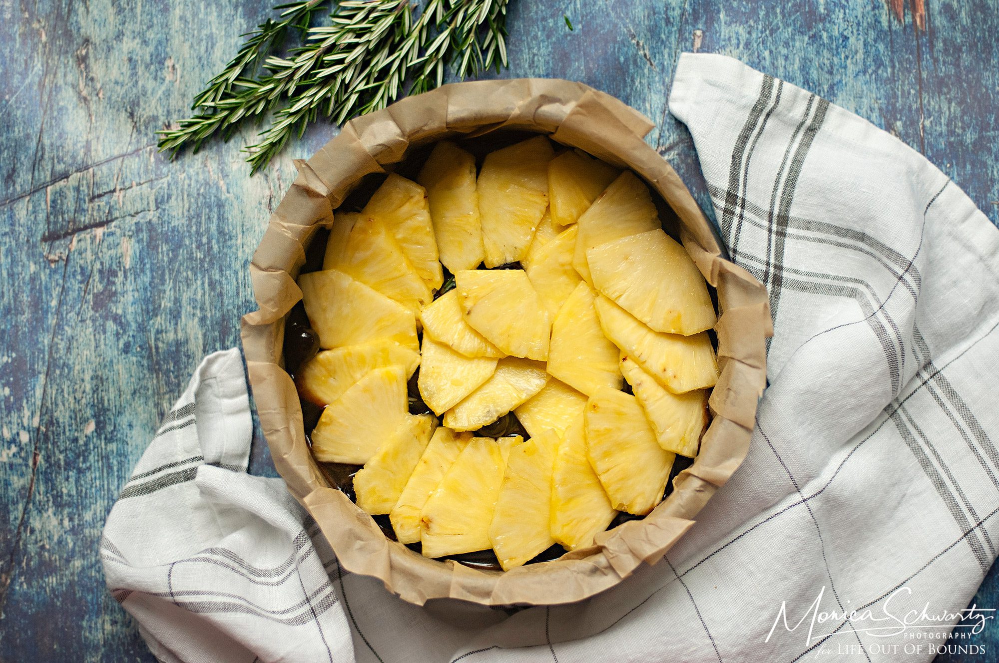 Layering-pineapple-slices-for-pineapple-upsidedown-cake-with-rosemary