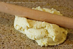 Rolling out the semolina dough to make Gnocchi Alla Romana, recipe