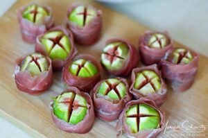 Freshly cut green figs wrapped in speck