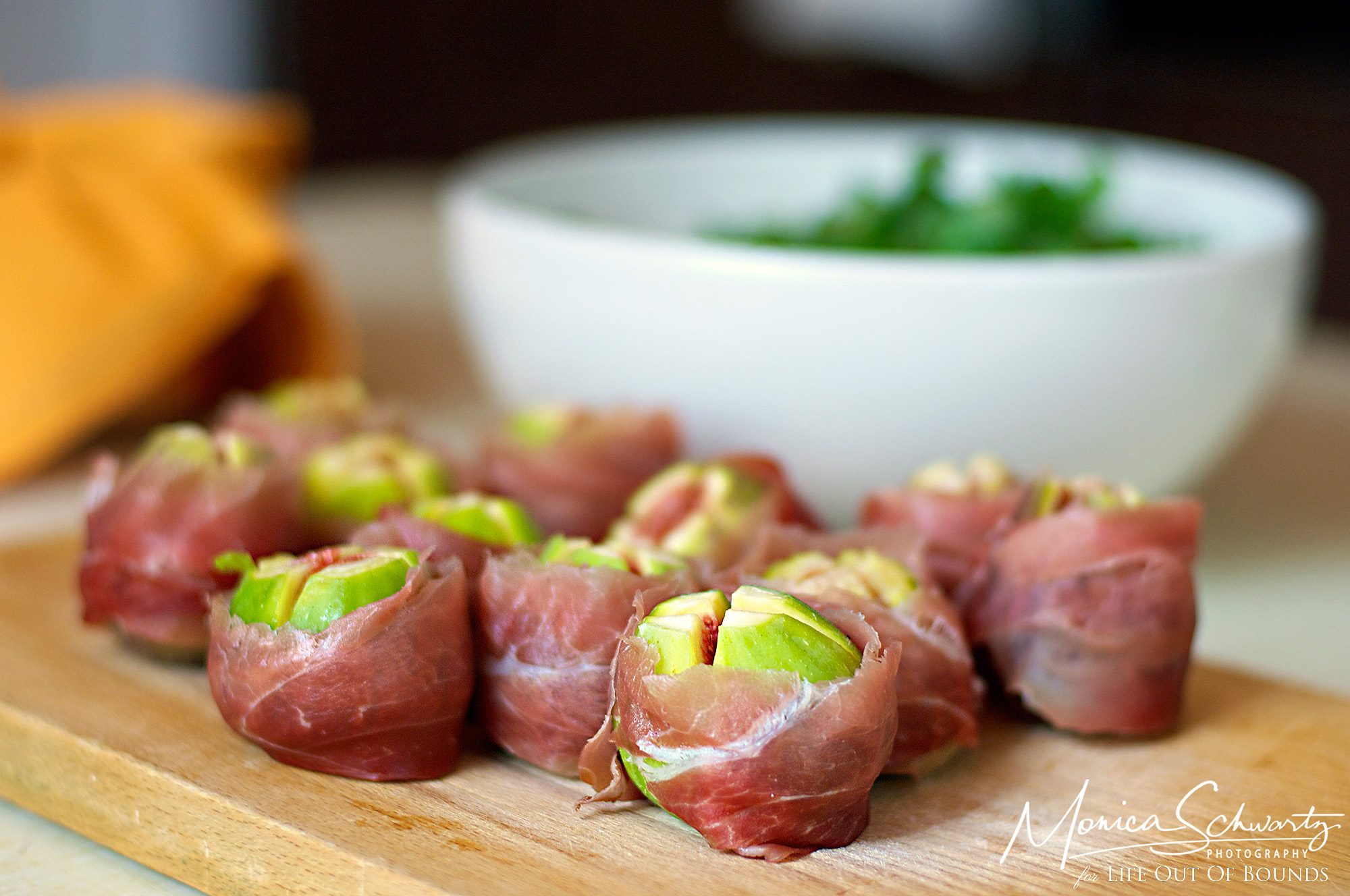Freshly cut green figs wrapped in speck